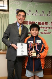 The Club!|s Executive Director, Charities, Douglas So (left) and Luk Tsz-ting, a ten-year-old Primary 5 student from Si Yuan School of the Precious Blood, who suggested  !MGXh?Ag!L as the new Chinese term for dementia.