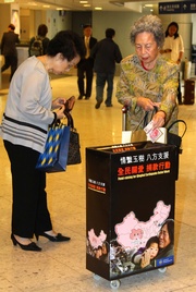 Photo 1 & 2:    Members of the public support the Club's fund-raising drive by putting money into the collection boxes.