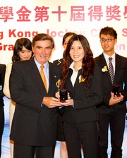 Hong Kong Jockey Club Chairman T Brian Stevenson (left) presents a graduation pin to scholar Daisy Leung from The Hong Kong Polytechnic University.