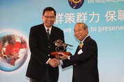 The Hong Kong Jockey Club Chairman John Chan (right) presents a souvenir to Mr Lau Kai-hung, Deputy Director of Housing Department, thanking the Housing Department for its support to the Club.