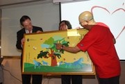 CARE@hkjc Volunteer Team members present a special souvenir made by the team to Chief Secretary for Administration Henry Tang.