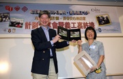 The Salvation Army's Social Services Director, Victoria Kwok presents a specially hand-made photo album to The Hong Kong Jockey Club's Executive Director, Charities, William Y Yiu.
