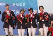 Jubilant Hong Kong Equestrian Team members Kenneth Cheng (from right to left), Samantha Lam, Jacqueline Lai and Patrick Lam receive the bronze medal of the team jumping event at the 11th National Games of the People!|s Republic of China.