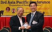 Hong Kong Jockey Club Chairman John C C Chan (left) presents a plaque to Deputy Chairman of Hong Kong Federation of Insurers Allan Yu at the Opening Ceremony.